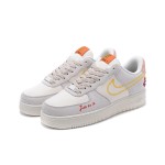 Nike Air Force 1 Low WMNS "Just Do It" sneakers in beige with yellow stitching and graphic details