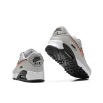 Grey Nike Air Max 90 sneakers with black and orange Swoosh accents, showcasing bold contrast and modern style.