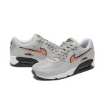 Grey Nike Air Max 90 sneakers with black and orange Swoosh accents, showcasing bold contrast and modern style.