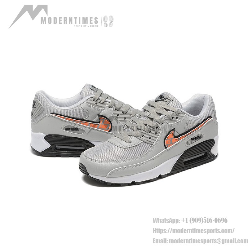 Grey Nike Air Max 90 sneakers with black and orange Swoosh accents, showcasing bold contrast and modern style.