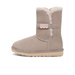 UGG Damen Bailey B2S Oyster 1153612 - Bequeme Schaffell-Mittelstiefel mit stylischem UGG-Riemen